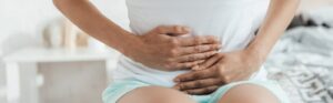 Frau mit Schmerzen durch Morbus Crohn oder Colitis ulcerosa